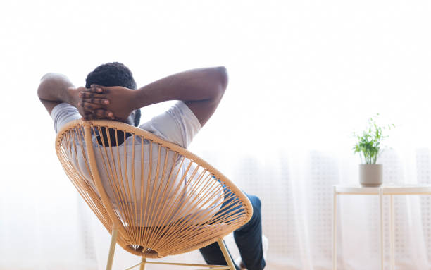 istock Man Relaxing in a Stylish Chair While Enjoying Natural Light From a Window 2194366787