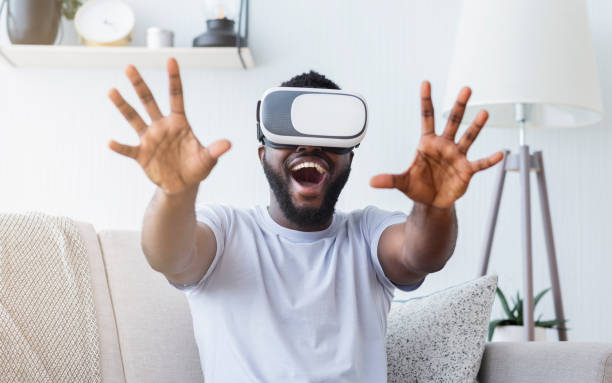 istock Excited Man Enjoying Virtual Reality Experience While Sitting on a Couch in a Modern Living Room 2194366883