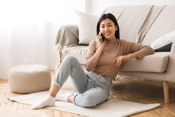istock Young Woman Enjoys a Phone Call While Relaxing at Home in a Cozy Setting With Comfortable Furniture 2194367032