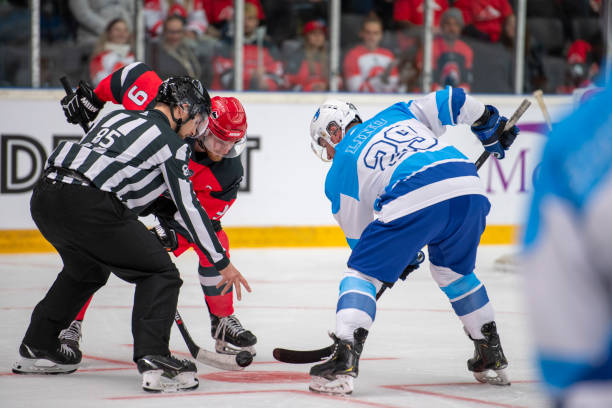 istock Ice Hockey Face off Action: Referee drops the puck between two eager players 2194368117