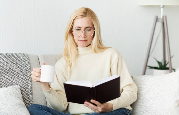 istock Woman Enjoying a Quiet Afternoon Reading a Book While Sipping Coffee at Home 2194368743