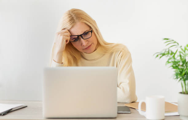 istock Woman Working on a Laptop in a Bright Room While Looking Thoughtful and Focused 2194368751