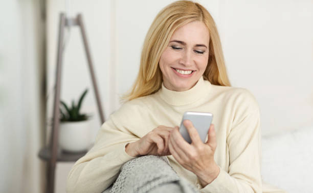 istock Happy Middle-Aged Woman Surfing Internet On Phone 2194368836