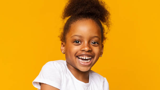 istock Young Girl Smiling Joyfully Against a Bright Yellow Background During a Studio Session 2194368977