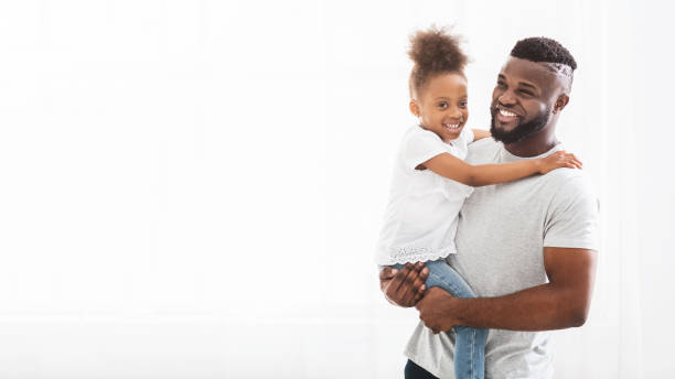 istock Father Joyfully Holding Daughter in Bright Indoor Setting 2194369441