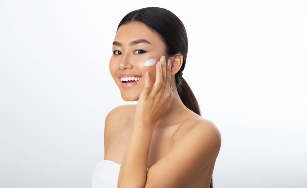 istock Beauty Concept. Asian Woman Applying Moisturizer On Face 2194370371