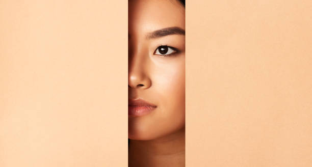 Close up of a Woman's Face Partially Hidden Behind a Solid Surface at a Neutral Setting