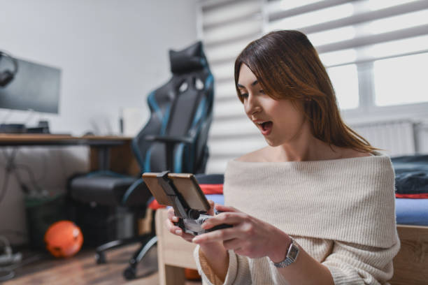 Female in Disbelief Staring at Phone Screen With Open Mouth After Winning Difficult Game Round