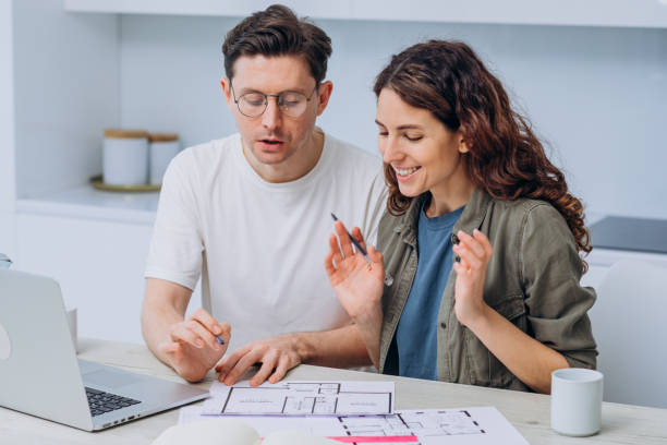 istock Happy couple working on home renovation plans at table with laptop 2194370865