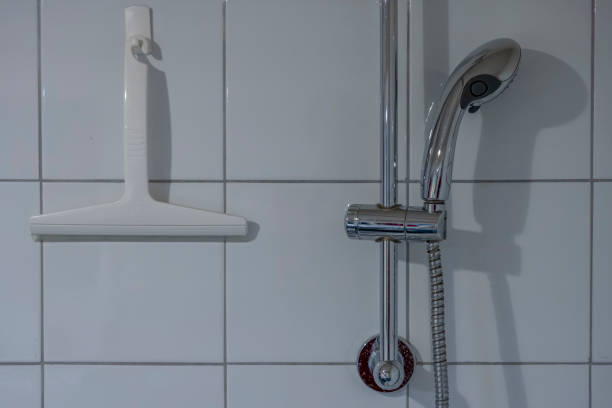 istock Paris, France - 01 12 2025: A squeegee and a shower head hanging on tiled wall 2194371353