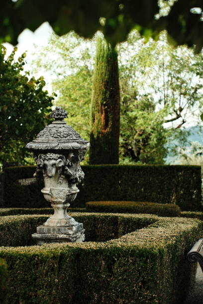 istock Decorative stone fountain surrounded by trimmed hedges in a serene garden setting 2194371418