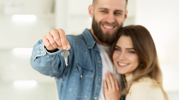 istock New Home Owners. Loving Couple Showing Key 2194372868