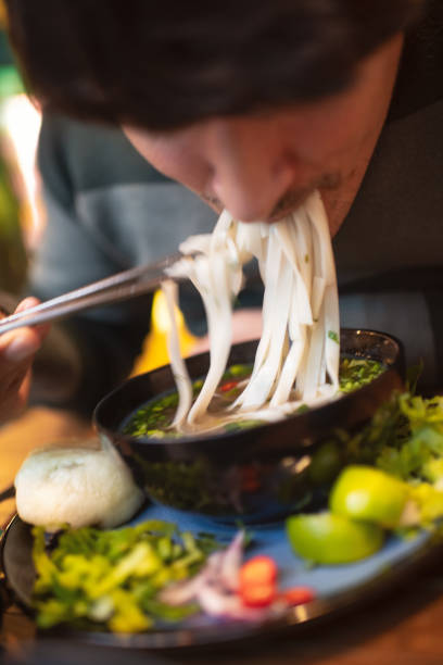 istock Man eating Vietnamese dish Pho soup in a cafe 2194372921
