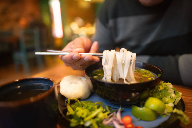 istock Man eating Vietnamese dish Pho soup in a cafe 2194372963