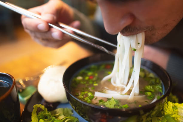 istock Man eating Vietnamese dish Pho soup in a cafe 2194372976