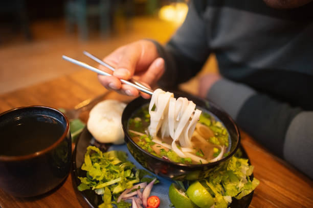 istock Man eating Vietnamese dish Pho soup in a cafe 2194373001
