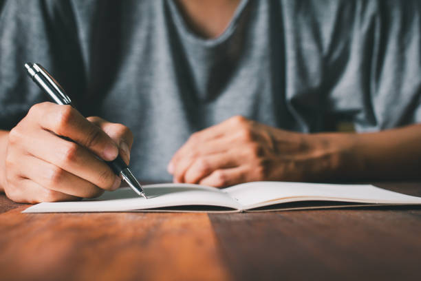 istock student writes in notebook, focusing on study homework, exam preparation. The moment learning and the pursuit of knowledge in an educational setting. Close up 2194376431