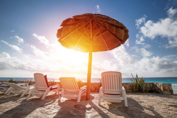 Caribbean beach with grass umbrellas and beds. Vacation concept