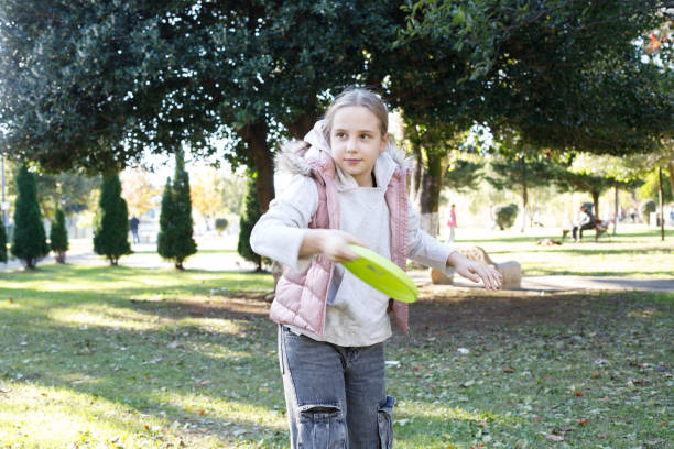 istock Cute young girl throwing flying disc outdoors. Vacation and holiday concept 2194379902