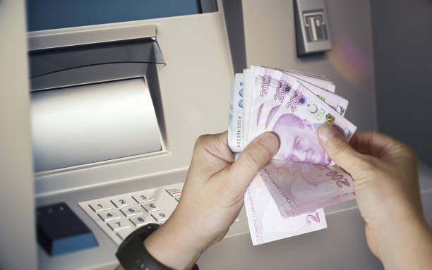 istock Counting and withdrawing Turkish Lira banknotes from an ATM machine 2194381499