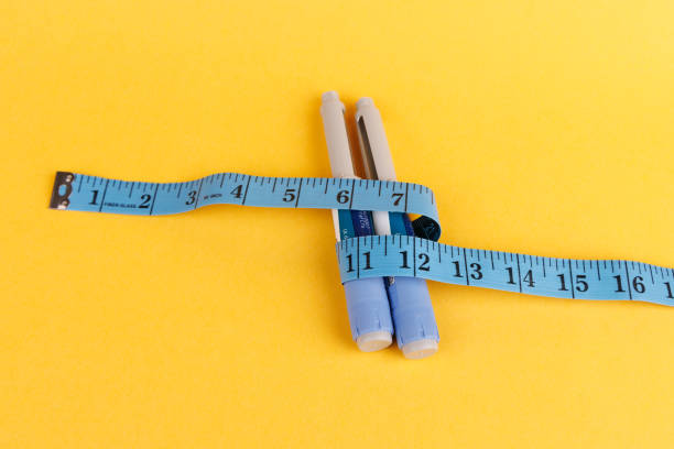 istock Diabetes control pens and blue tape on a yellow surface 2194381629