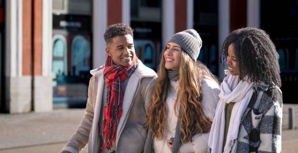 istock Three happy multi-ethnic young students walking together on a city street during wintertime, enjoying their free time 2194383071