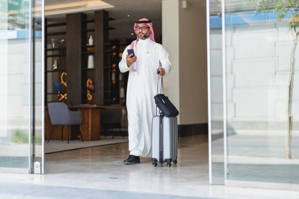 istock Confident Middle-Aged Arabic Businessman with Smartphone Leaving Hotel 2194383747