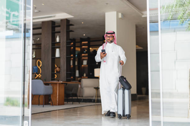 istock Confident Middle Eastern Businessman Exiting Hotel With Smartphone 2194383749