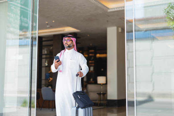 istock Confident Arabic Businessman Exiting Hotel with Smartphone 2194383753