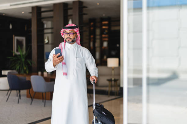 istock Confident Arabic Businessman Exiting Hotel with Smartphone 2194383754