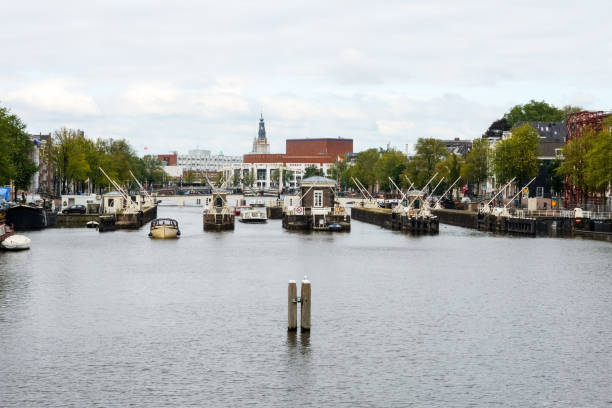 Amstel river in Amsterdam with the famous skinny bridge (magere brug) in the centre of the photo. The town hall and music theatre Stopera are located in the background.