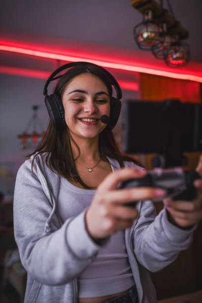 istock Happy Female Gamer Communicating With Virtual Friends While Playing Game on Phone With Joystick 2194385106
