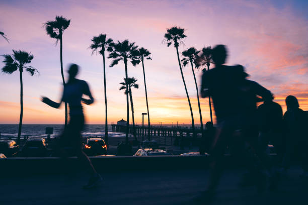 A couple in love walks on the beach in California during a beautiful sunset by the pier
