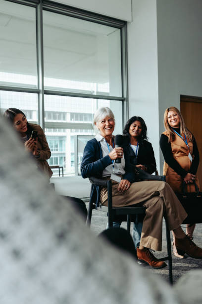 istock Mature businesswoman speaking at a conference with a smiling diverse audience 2194386049