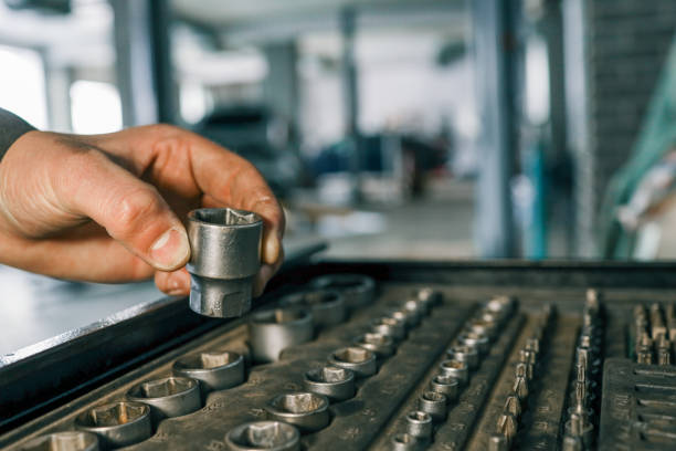 istock Hand selecting a metal socket wrench piece from an organized tool tray in a workshop setting, symbolizing precision and automotive repair 2194386743