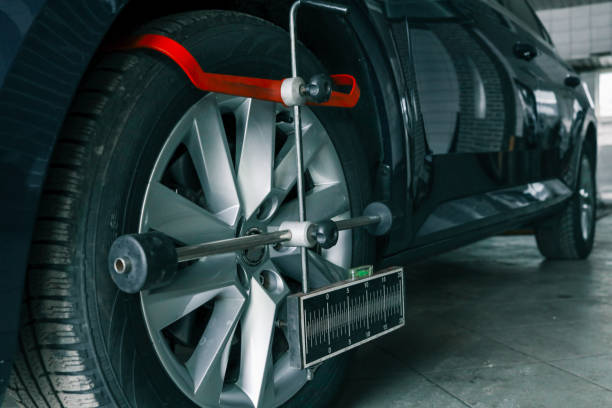 istock Close-up of a car wheel being measured for alignment using professional calibration equipment in an auto workshop 2194386751