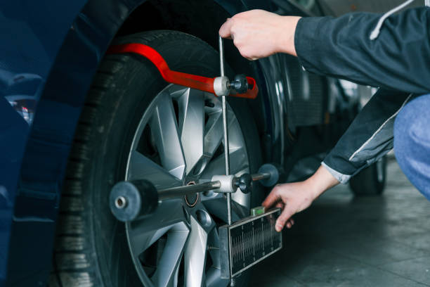 istock Mechanic adjusting a car's wheel alignment using a professional measuring tool in an auto repair shop. Close-up on the wheel and equipment 2194386756