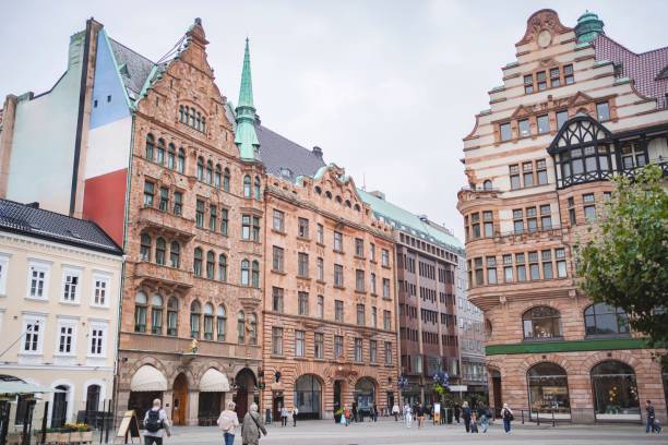 Tourists walking in lilla torg, a small public square in the city of malmo, sweden, featuring colorful historic buildings