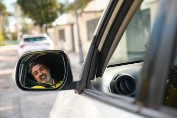 istock Happy worker driving and looking at side mirror 2194388820