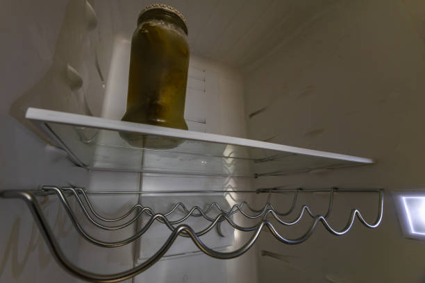 istock Empty shelves in the fridge, a jar with pickled cucumbers 2194389963