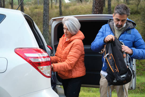 istock Senior couple preparing for hiking trip, taking backpack from car trunk 2194390116