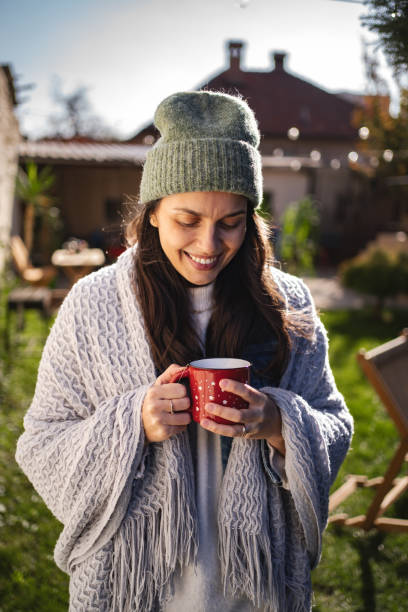 istock Young woman enjoying hot beverage in backyard during autumn 2194391366