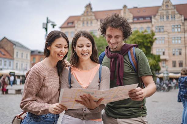 Three tourists consulting a map in a square in malmo, sweden