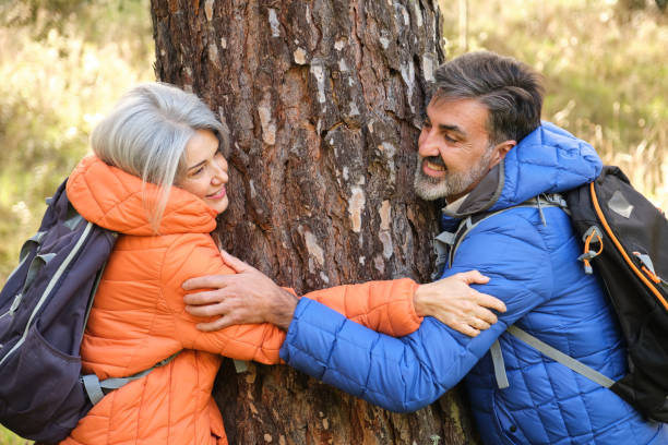 istock Senior hikers hugging a tree in the forest 2194392067
