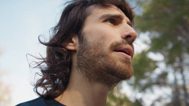 istock Long Haired Man Talks Suspiciously With Distrustful Passers-by in the Park 2194392430