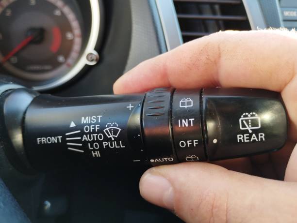 istock Black handle for switching the operating mode of car wipers. Human hand on the wiper switch. 2194394529