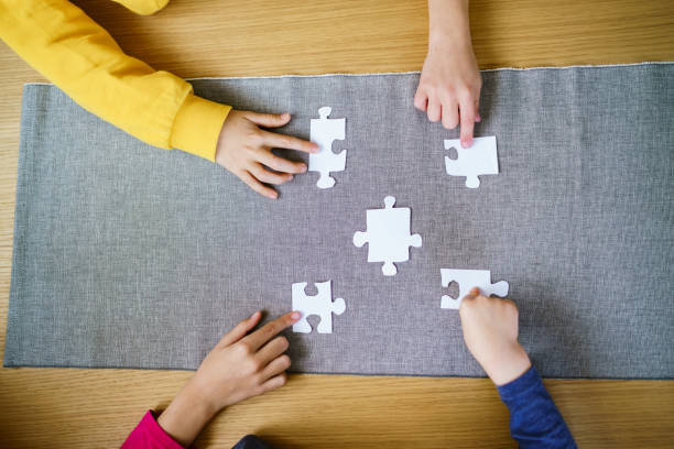 istock Children's hands put puzzle pieces together 2194397429