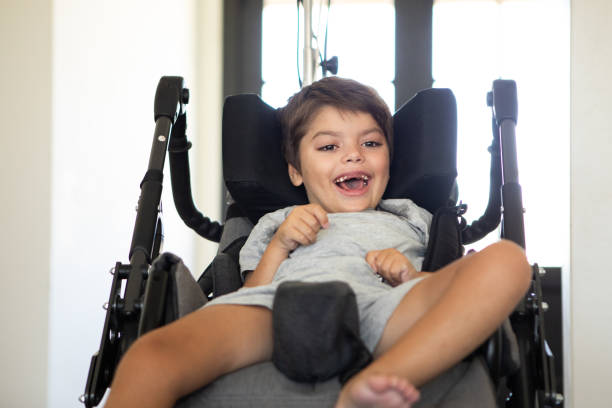 istock Smiling boy with cerebral palsy in his wheelchair 2194399607