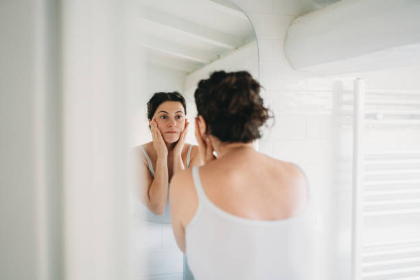 istock Woman checking her face in the bathroom mirror 2194400515