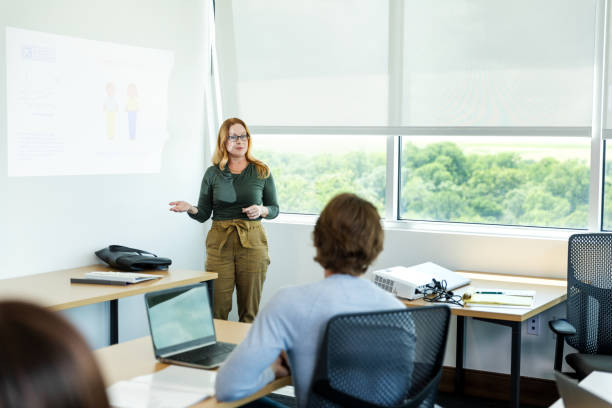 istock Female Professor Giving a Presentation to Students in Classroom 2194401475